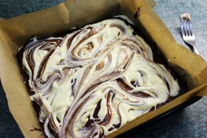 Swirl the top layer of orange cheesecake mixture into the brownie mixture underneath to give a lovely marbled effect.