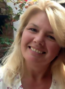 Woman with blond hair looking happy smiling at the camera