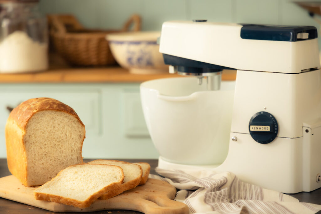 bread made with a vintage stand mixer homemade white bread sliced on a bread board with a vintage Kenwood stand mixer