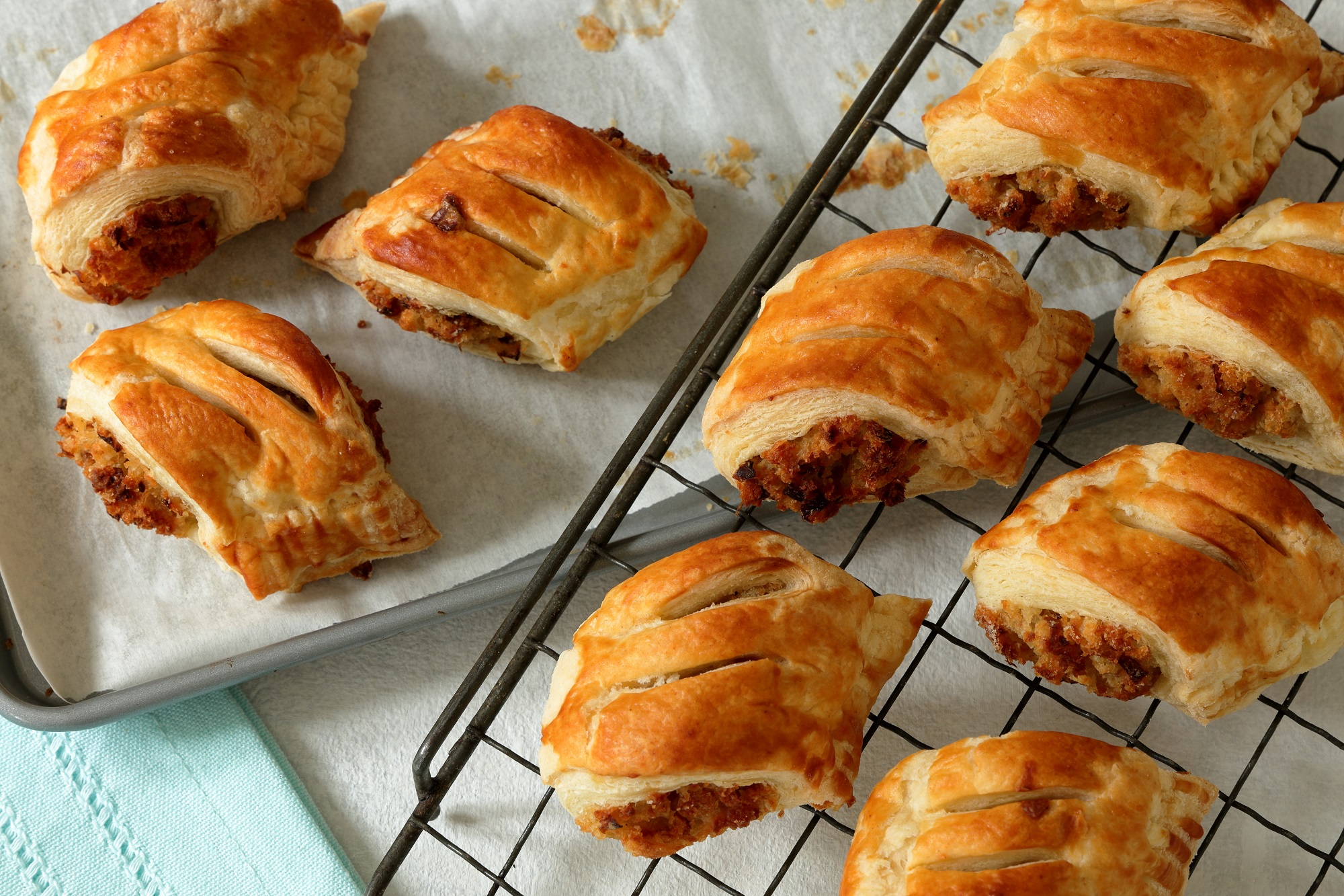 Vegetarian cheese and onion sausage rolls cooling on a wire rack after baking