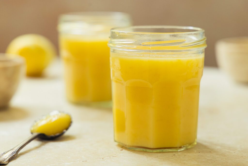 lemon curd recipe A close-up shot of a glass jar filled with vibrant yellow homemade lemon curd made from an authentic 1932 vintage recipe